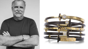 A black and white photograph of jewelry designer pat flynn with a stack of his hand forged black iron nail bracelets featuring diamond accents and 22k yellow gold dust