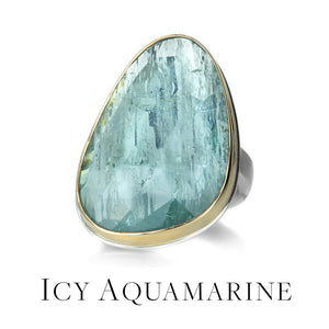 A large, faceted, organically shaped aquamarine ring, set in a 14k yellow gold bezel on a sterling silver band, handcrafted by jewelry designer Jamie Joseph. Link to the icy aquamarine collection