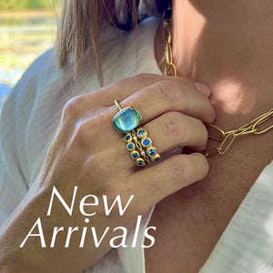 A model wearing a stack of blue sapphire rings by jewelry designer Marian Maurer, a rectangular aquamarine ring by jewelry designer Gabriella Kiss