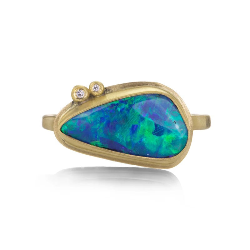 Gold ring with a large blue opal stone on a white background