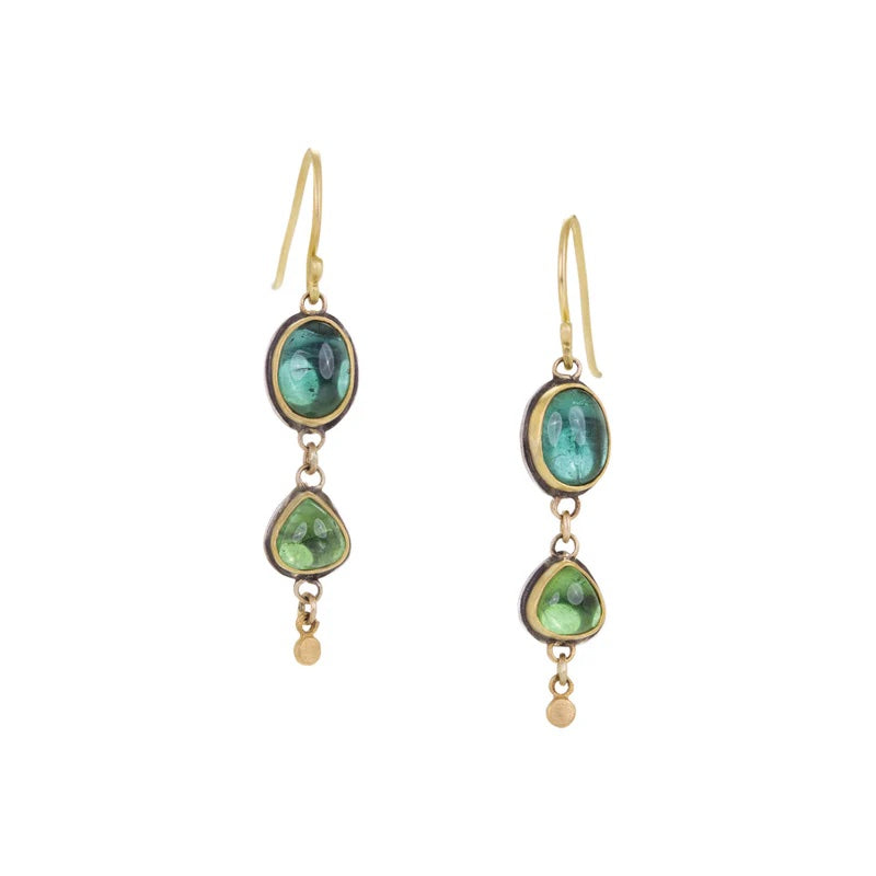 Gold earrings with green gemstones on a white background