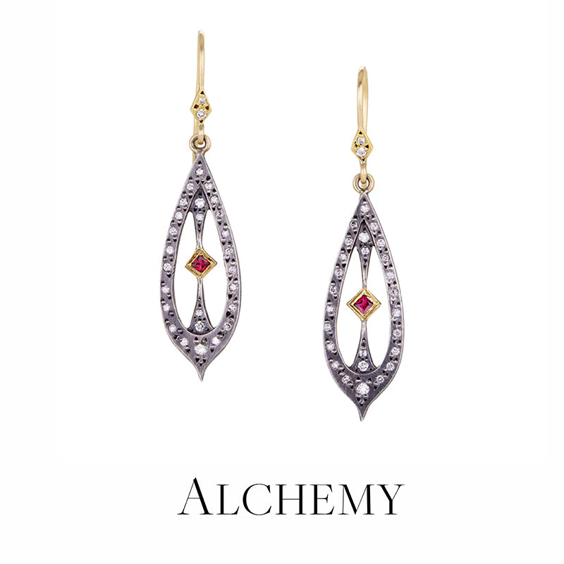 Pair of gold and silver earrings with red gemstones on a white background, branded 'Alchemy'.