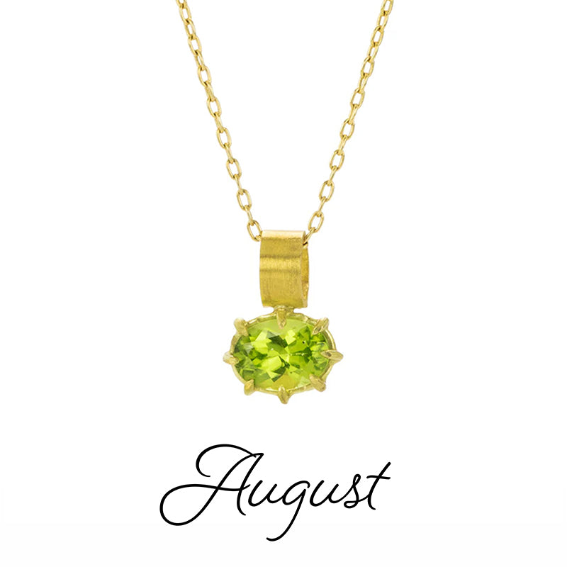A delicate gold chain with an oval, faceted, green peridot set in prongs. 