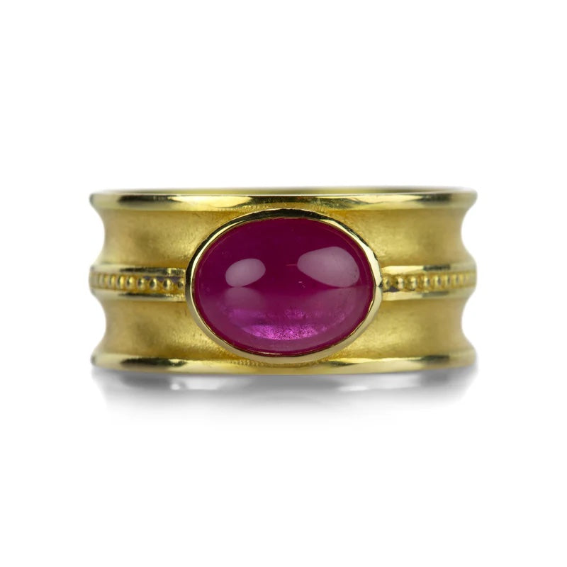Gold ring with a pink gemstone on a white background