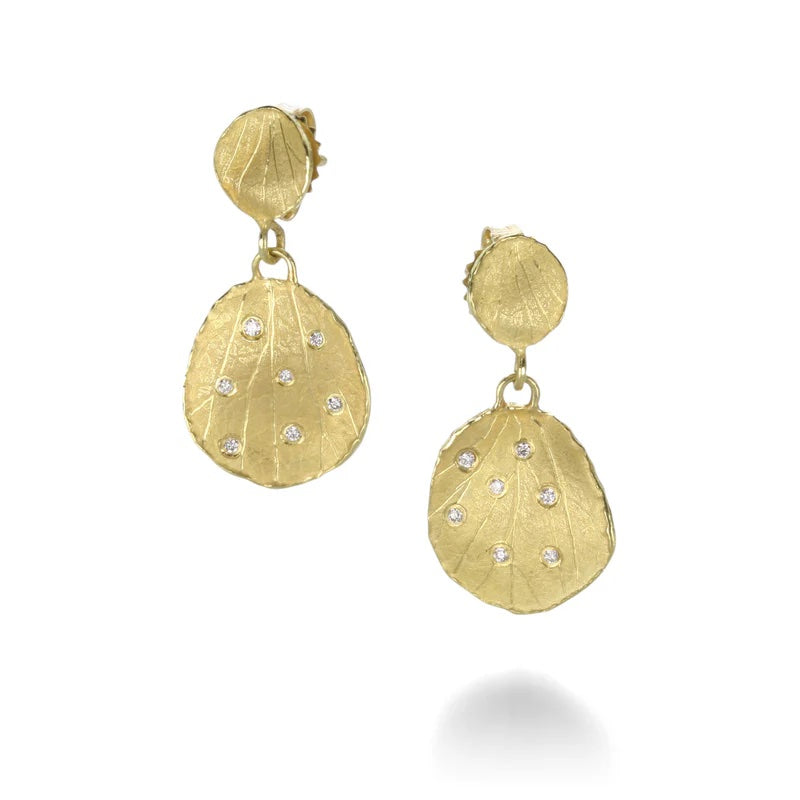 Gold earrings with leaf-like design and embedded stones on a white background