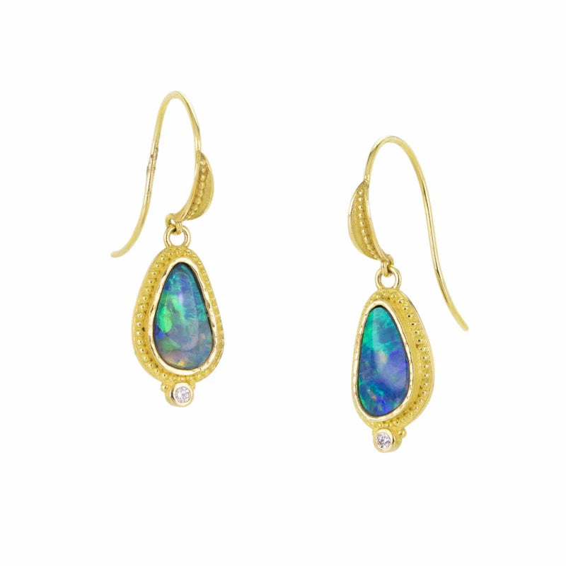Gold earrings with opal stones on a white background