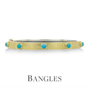 Gold bangle with turquoise stones on a white background