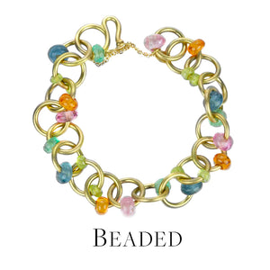 A heavy, 18k yellow gold round link bracelet with multicolored cabochon sapphire beads, handcrafted by jewelry designer Mallary Marks. Link to the beaded bracelets collection