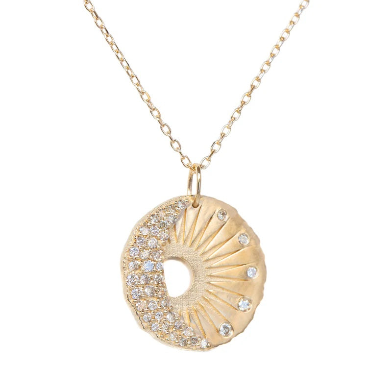 Gold necklace with a circular pendant on a white background