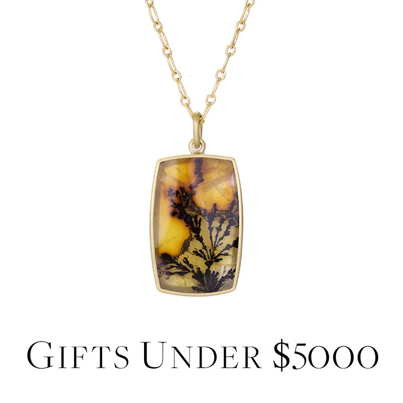 Gold necklace with a pendant featuring a natural stone design on a white background.