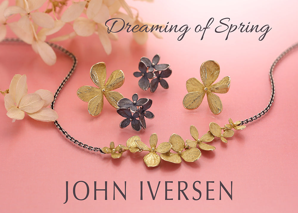 Floral jewelry set with 'Dreaming of Spring' text and 'John Iversen' branding on a pink background.