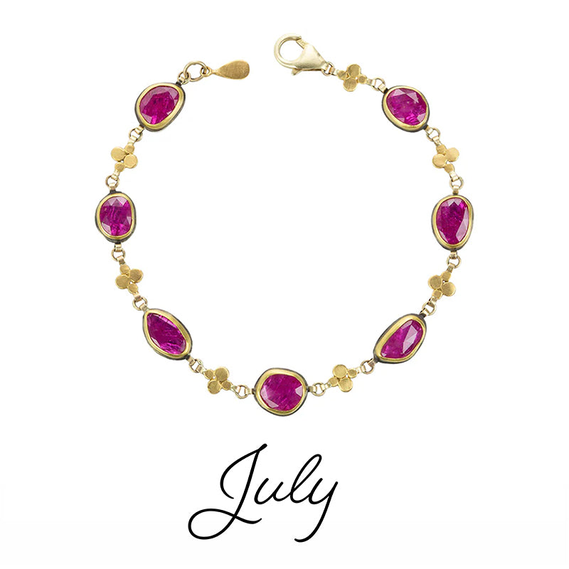 Gold bracelet with pink gemstones on a white background, labeled 'July'.