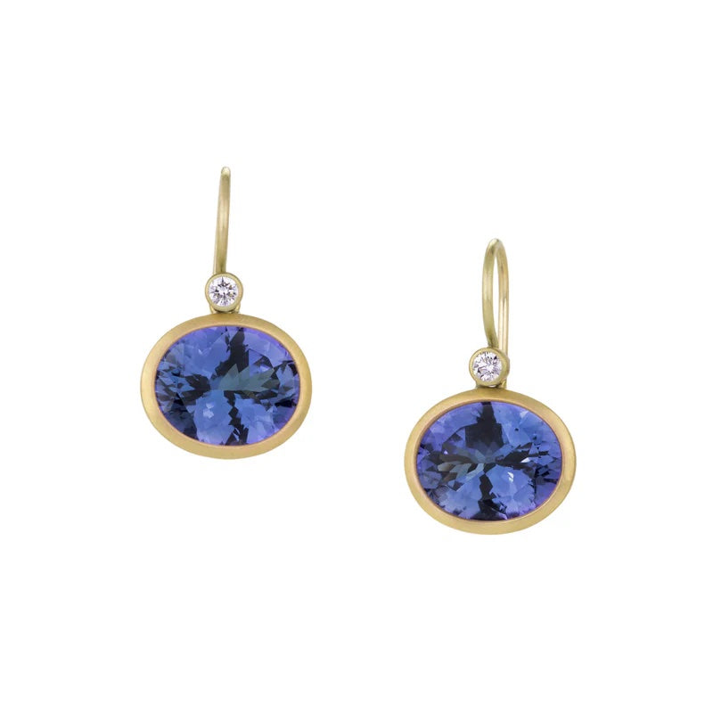 Gold earrings with blue gemstones on a white background