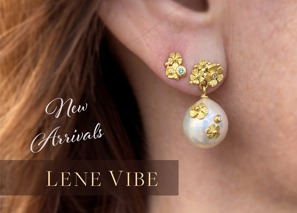 A model wearing a small 18k yellow gold flower cluster stud with a blue diamond paired with a large white south sea pearl earring with carved flower accents by jewelry designer Lene Vibe