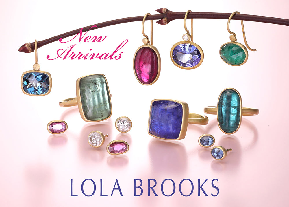 Jewelry set with rings and earrings on a branch, featuring colorful gemstones, with 'Lola Brooks' branding.