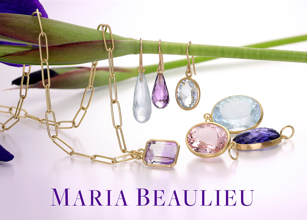 Jewelry set with colorful gemstones and a gold chain on a white background, featuring the brand 'Maria Beaulieu'.