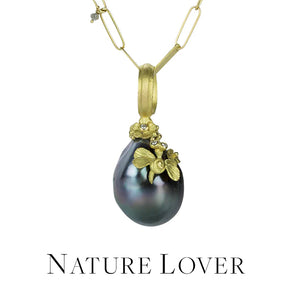 An 18k yellow gold chain with a dark gray tahitian pearl with a carved winged critter with diamond eyes and carved flowers. Handcrafted by jewelry designer Lene Vibe. 