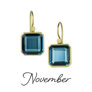 A pair of 18k yellow gold earrings with portrait cut London blue topaz drops. Handcrafted by jewelry designer Lola Brooks. 