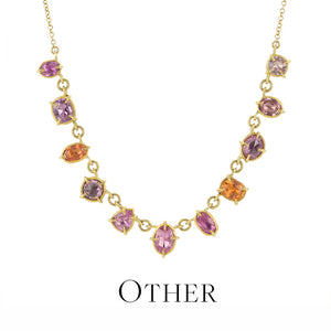 Gold necklace with multicolored gemstones on a white background
