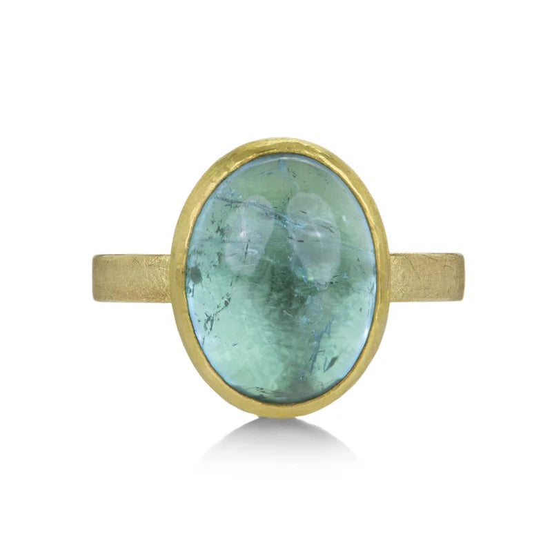 Gold ring with a green gemstone on a white background