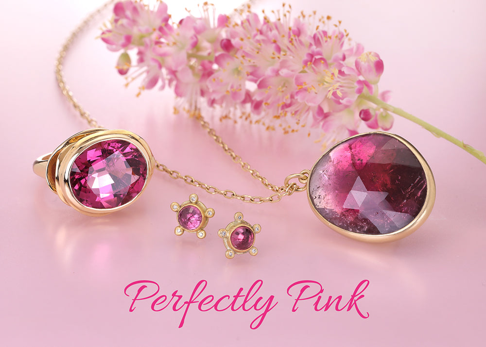 Gold jewelry set featuring a ring, pendant necklace, and small earrings with faceted pink gemstones, styled with pink flowers on a pink background with the text 'Perfectly Pink'.