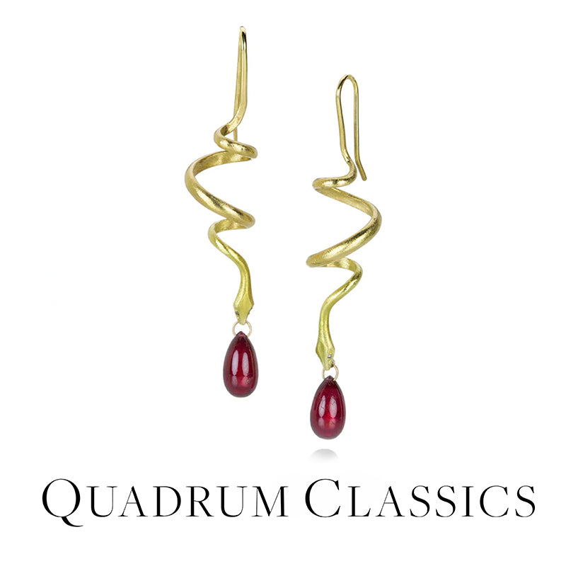 Gold spiral earrings with red teardrop stones on a white background, branded 'Quadrum Classics'.