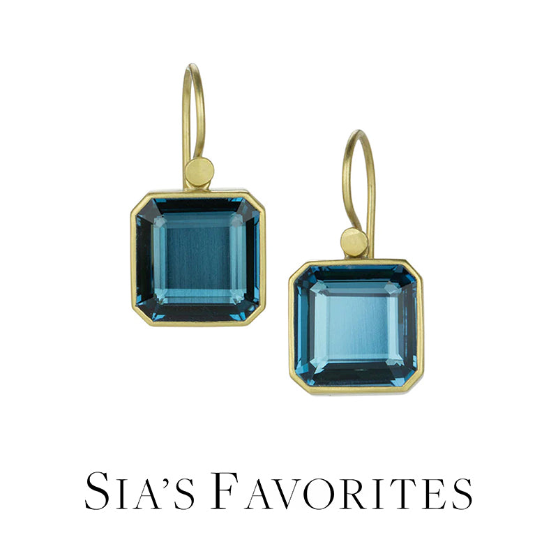 Gold earrings with blue gemstones on a white background, labeled 'Sia's Favorites'.