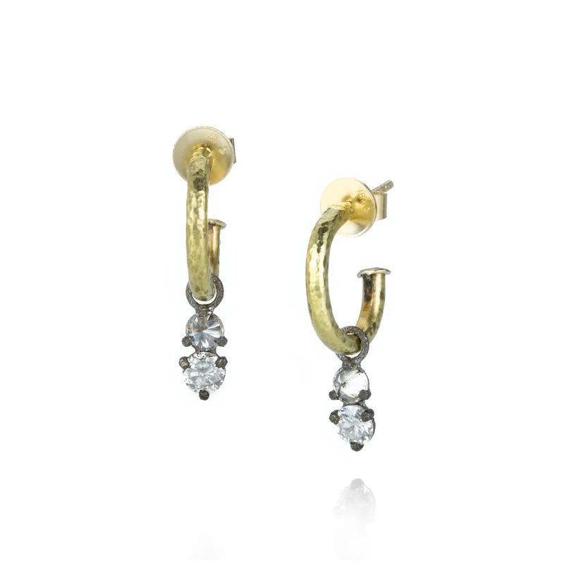 Gold hoop earrings with diamond-like stones on a white background